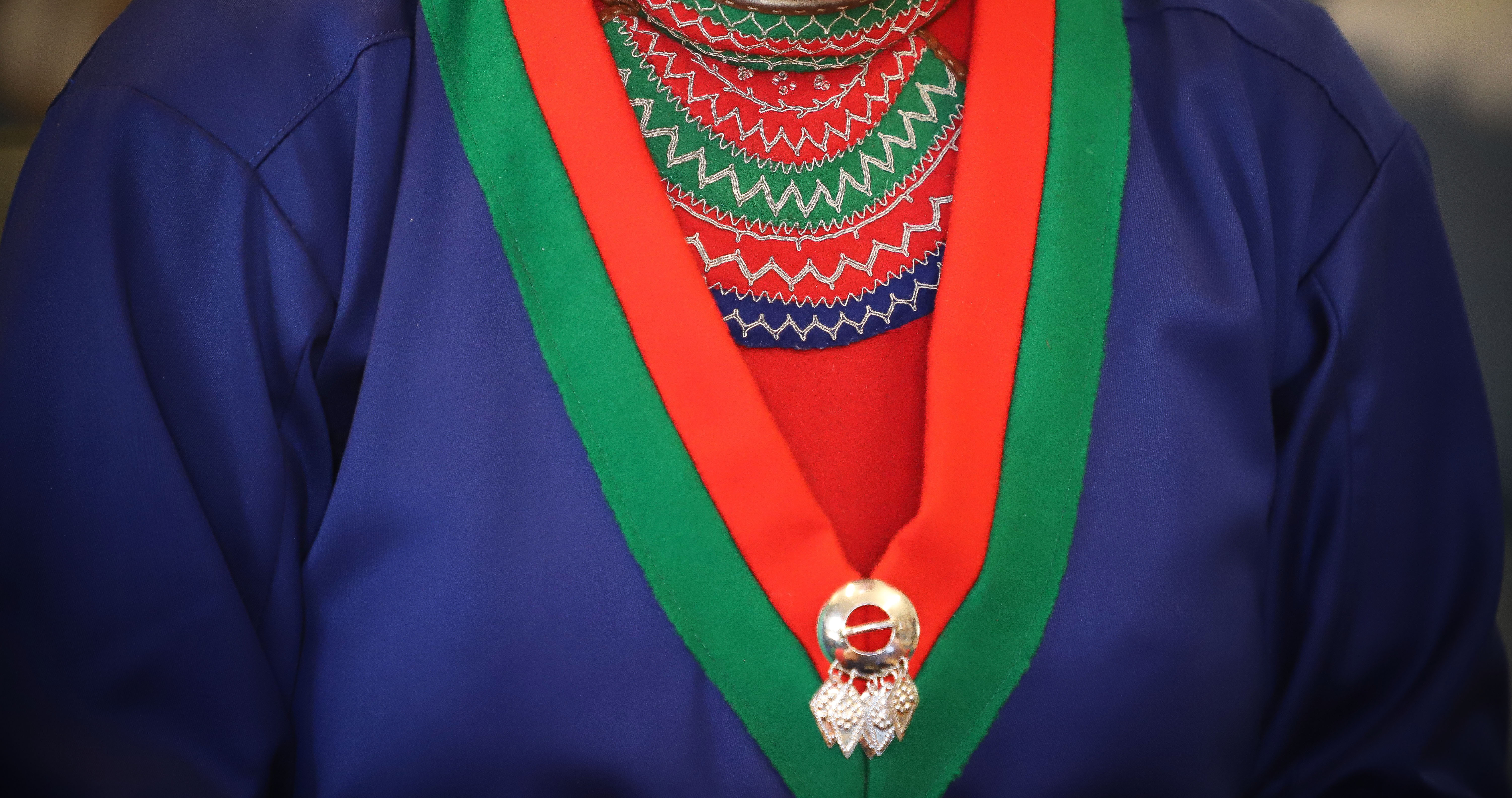 Barmklädet med tenntrådsbroderier som hör till kolten. Foto: Karin Skoglund.